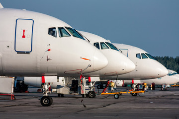 Close-up passenger airplane noses in line at the parking lot of airport