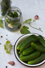Preservation of pickling cucumber. Preparation of conservation from organic vegetables on a light background. Homemade organic crunch green pickles in a jar. Copy space