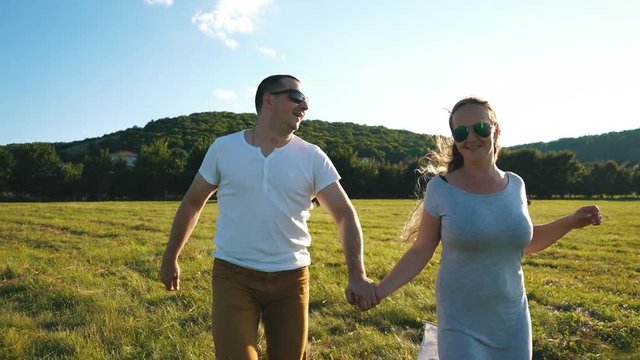 a young couple in love running through the field holding hands