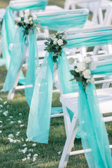 White chairs for guests decorated with mint cloth