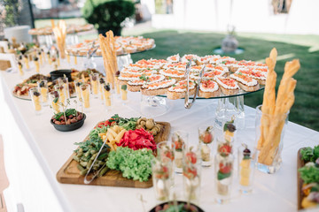 Long dinner table with delicious salty snacks