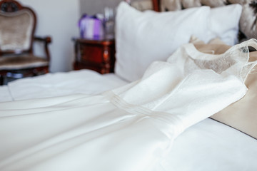 Fototapeta na wymiar White wedding dress lies on the bed