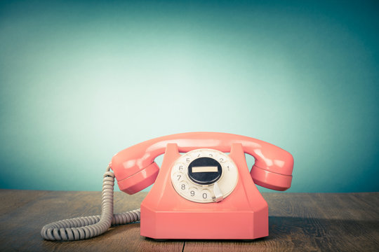 Retro old telephone on table front mint green background. Vintage style filtered photo