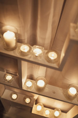 White candles shine on the shelves