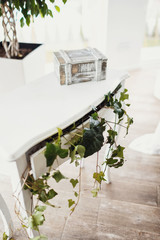 Little white table decorated with greenery