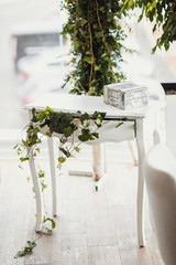 Little white table decorated with greenery