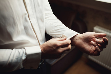 Obraz premium Man fixes the cufflinks on his wirsts