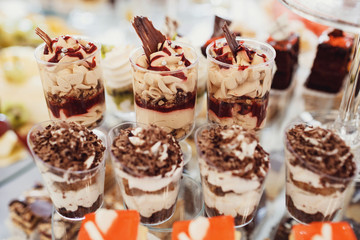 Delicious fancy cakes made of chocolate and cheese stand on the table