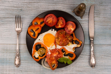 Healthy breakfast - fried eggs with tomatoes and pepper