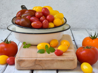 Tomatoes of different varieties and colors on a light background. Healthy food. Preparation for pickling