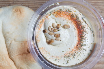 Hummus with cedar nuts in the jar and fresh pita