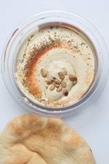Hummus with cedar nuts in the jar and fresh pita