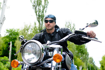 Fototapeta na wymiar Biker man with glasses on a motorcycle.