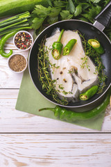 Raw fresh white fish steak with vegetables ingredients