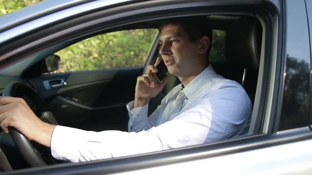 Succesful bussinessman talking on phone in car