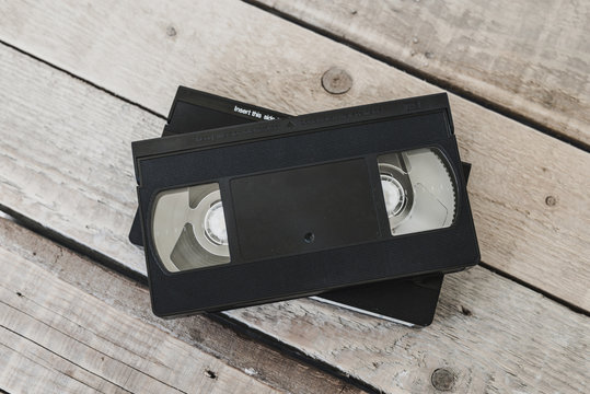  Stack Of VHS Video Tape Cassette On White Wooden Table, Retro Filter