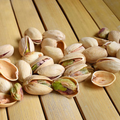 Pistachio nuts on bamboo table.