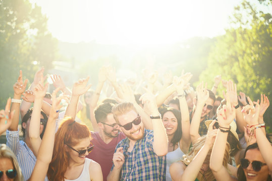 Crowd of people at music festival dancing and enjoying music