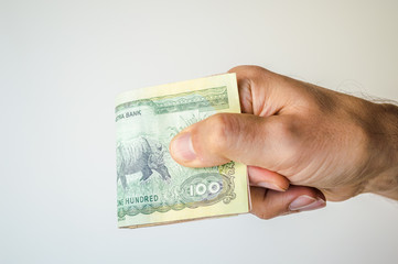 Man holding Nepal Rupees notes in his hand