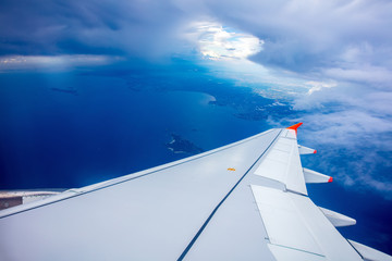 Obraz premium Wing of airplane, clouds and blue sky, view from the window of airplane. 