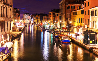 Venice at night long exposure photo with traces of boats on a water.