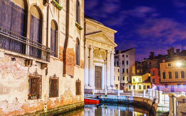 Obraz na płótnie Canvas Night lights at Venice with typical Venetian buildings and canals with boats.