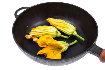 Yellow pumpkin flowers and zucchini in frying pan for cooking