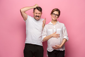 The funny surprised handsome man and his beautiful pregnant wife's tummy