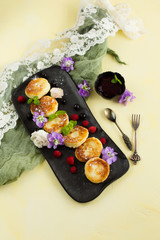Cheesecake on a dark plate, garnished with berries