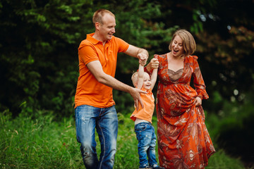 Parents have fun with their son in the forest