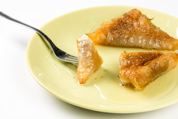 Traditional balkan baklava pie with walnuts served on the plate over white background