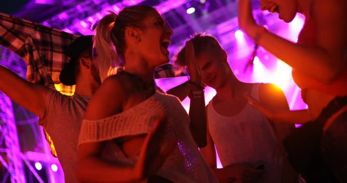 Group of friends having fun and dancing at concert