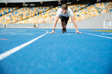 Young male athlete standing in a start position