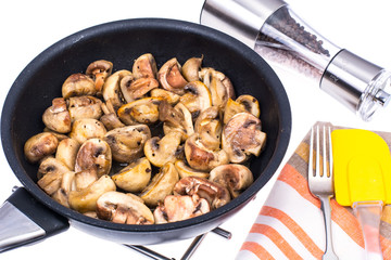 Halves of champignons fried in frying pan