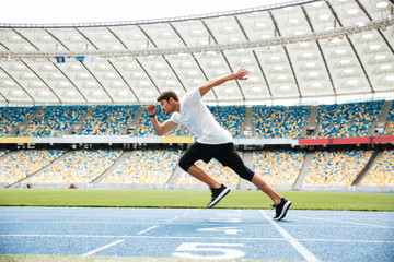 Side view of a sport man running on a racetrack