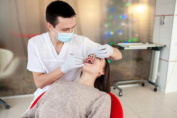The dentist is treating teeth with a beautiful girl.