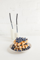 fresh breakfast of waffles with blueberries and milk