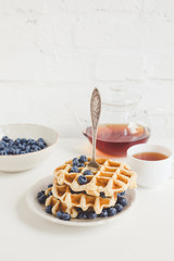 healthy breakfast of waffles with blueberries and tea