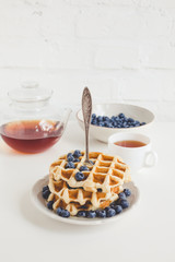 tasty breakfast of waffles with blueberries and tea
