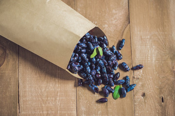 Fresh honeysuckle blue berry fruits with leaf on a wooden background