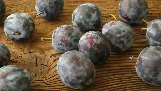 Delicious plums on the old wooden background
