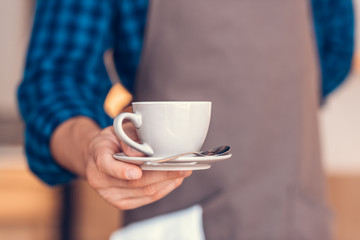 barista holding cup of coffee