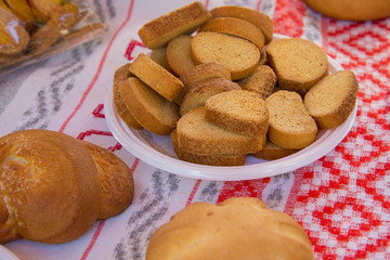 Crackers in a dish and baking on the tablecloth with embroidery in the form of the national Belarusian ornament. products presented at the town fair.