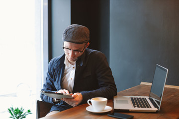 Shot of a young businessman working on his laptop in a cafe shop. Selective focus
