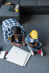 high angle view of african-american father and son doing renovation