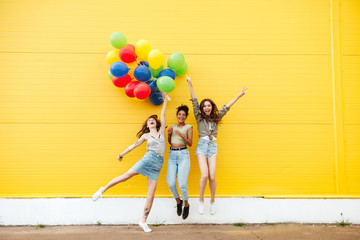 Happy women friends have fun with balloons.