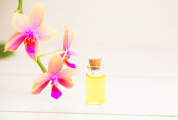 Essence of  orchid flowers on table in beautiful glass jar