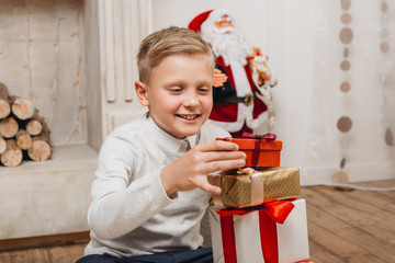 Obraz na płótnie Canvas boy making stack of christmas gifts