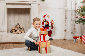 Obraz na płótnie Canvas boy making stack of christmas gifts