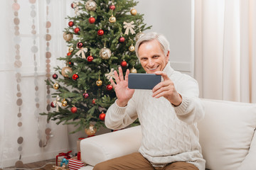 man taking selfie with christmas tree